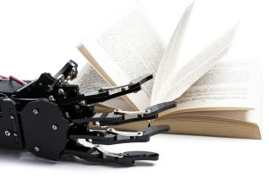 Real robotic hand and opened book. Concept of AI power and machine learning