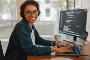 Afro american woman in headphones freelance data scientist work remotely at home office