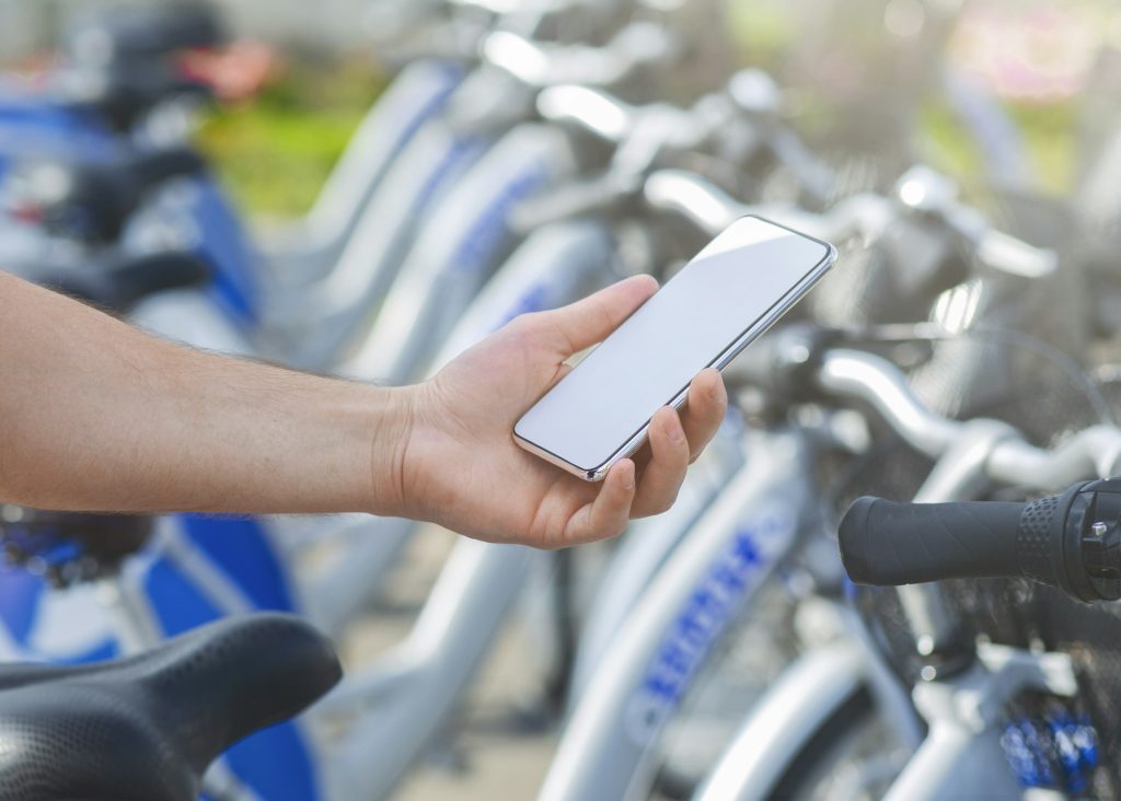 Man using mobile app at bikes sharing service, mockup