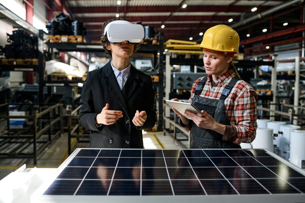 Young engineer using tablet while manager in vr headset making presentation