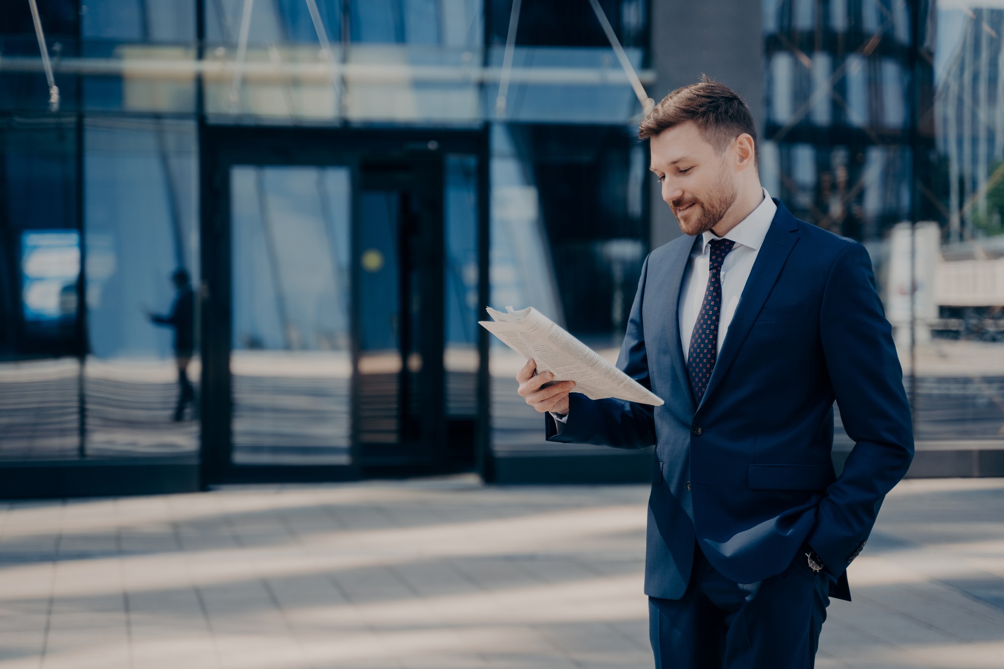 Male lawyer reading newspaper while walking to firm