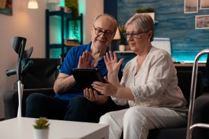 Married aged couple using tablet for video call meeting