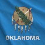 Oklahoma US state flag depicted on folded wavy fabric of old cloth